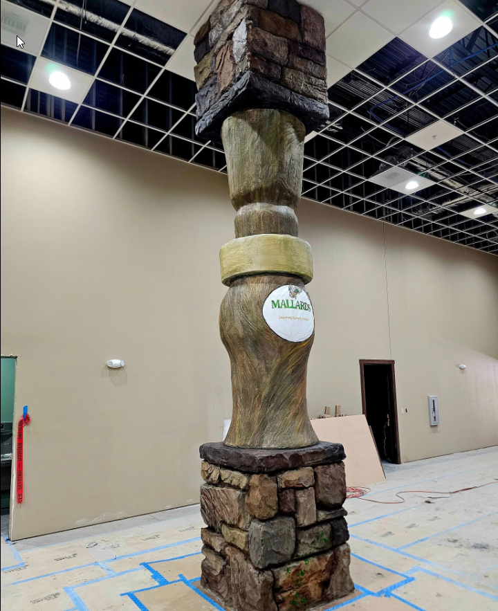 Structural column hand-carved in concrete to resemble stacked stone and timber